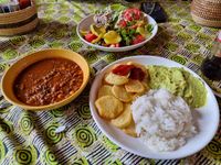 Chilie-con-Carne with rice Guacamole with fried potato slices and salad